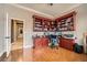 Home office with built-in cherry wood cabinets, desk, and wood flooring at 8032 Audubon Canyon St, Las Vegas, NV 89131