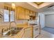 Cozy kitchen featuring light wood cabinets, laminate countertops, and white appliances at 813 Cherry Dr, Henderson, NV 89002