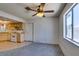 Open living room features gray carpet, ceiling fan, and flows into a bright kitchen space at 813 Cherry Dr, Henderson, NV 89002