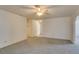 View of the living room with neutral carpet, a ceiling fan, and access to hallways at 813 Cherry Dr, Henderson, NV 89002
