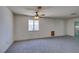 Large open living room featuring a ceiling fan, bright window, and sliding door access at 813 Cherry Dr, Henderson, NV 89002