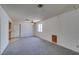 Open living room with neutral carpet, light-filled window, ceiling fan, and view of kitchen at 813 Cherry Dr, Henderson, NV 89002