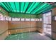 Sunlit room featuring paneled walls, a teal corrugated roof, and transom windows at 813 Cherry Dr, Henderson, NV 89002