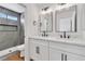 Bright bathroom features double vanity with modern fixtures, large mirrors, and a tiled shower at 831 Purple Sage Ter, Henderson, NV 89015