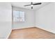 Minimalist bedroom features hardwood floors, a window, and a ceiling fan at 831 Purple Sage Ter, Henderson, NV 89015