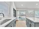 Bright kitchen with stainless steel sink, marble countertops, gray cabinetry, and backyard access at 831 Purple Sage Ter, Henderson, NV 89015