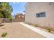 A gravel backyard with a walkway, minimal vegetation, and block wall fencing for privacy at 9011 Aldershot Ct, Las Vegas, NV 89147