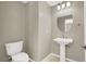 Charming half bathroom featuring a pedestal sink, decorative mirror, and tiled floor at 9225 Dalmahoy Pl, Las Vegas, NV 89145