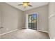 This bedroom includes plush carpet, large windows, and a sliding door to a balcony at 9225 Dalmahoy Pl, Las Vegas, NV 89145