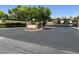 Tudor Park Queensridge entrance with stone columns, manicured landscaping, and secure wrought iron gate at 9225 Dalmahoy Pl, Las Vegas, NV 89145
