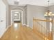 Upstairs hall featuring hardwood floors, chandelier, and arched doorway offering an inviting passage at 9225 Dalmahoy Pl, Las Vegas, NV 89145