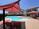 Community swimming pool with lounge chairs and umbrellas at 9225 Dalmahoy Pl, Las Vegas, NV 89145