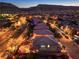 Aerial night view showcasing homes, city lights, and mountains in the background at 10243 Aragon Crown Rd, Las Vegas, NV 89135