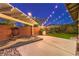 Inviting backyard with a patio, swing chair, string lights, and landscaping at 10243 Aragon Crown Rd, Las Vegas, NV 89135