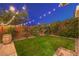 Cozy backyard featuring a small lawn, string lights, and a wine barrel accent at 10243 Aragon Crown Rd, Las Vegas, NV 89135