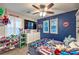 bedroom includes fun superhero decor, white dresser, ceiling fan and shuttered windows at 10243 Aragon Crown Rd, Las Vegas, NV 89135