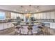 Open kitchen with white cabinets, large island, granite countertops, stainless steel appliances, and modern pendant lighting at 10243 Aragon Crown Rd, Las Vegas, NV 89135