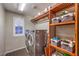 Laundry room featuring washer, dryer, storage shelves and a shuttered window at 10243 Aragon Crown Rd, Las Vegas, NV 89135