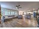 Open-concept living room featuring hardwood floors, a large sofa, and a view of the kitchen at 10243 Aragon Crown Rd, Las Vegas, NV 89135