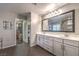 Main bathroom with double vanity, large mirror, and walk-in closet entrance at 10243 Aragon Crown Rd, Las Vegas, NV 89135