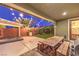 Cozy backyard featuring patio area, ample room for entertaining, wood table with benches, and string lights at 10243 Aragon Crown Rd, Las Vegas, NV 89135