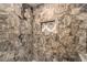 Walk-in shower featuring stone walls and a built-in shampoo niche at 10243 Aragon Crown Rd, Las Vegas, NV 89135