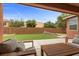 Relaxing covered patio with comfortable seating overlooking the well-maintained backyard at 10300 S Dapple Gray Rd, Las Vegas, NV 89178