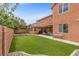 Beautiful backyard featuring an artificial grass lawn, tall stucco fence, and patio at 10300 S Dapple Gray Rd, Las Vegas, NV 89178