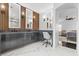 Elegant bathroom with dual sinks, wood accent wall, marble floors, and a view into the main bedroom at 10300 S Dapple Gray Rd, Las Vegas, NV 89178