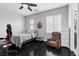 Inviting bedroom with hardwood floors, a ceiling fan, and a comfortable armchair at 10300 S Dapple Gray Rd, Las Vegas, NV 89178