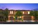 Charming two-story home with well-manicured landscaping and a welcoming front entrance at dusk at 10300 S Dapple Gray Rd, Las Vegas, NV 89178