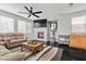 Cozy living room with a fireplace, TV, plush sofa, and dark wood floors at 10300 S Dapple Gray Rd, Las Vegas, NV 89178