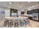 Modern kitchen featuring a large island with seating, granite countertops, and stainless steel appliances at 10319 Larkmead Ave, Las Vegas, NV 89149