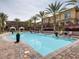 Beautiful community pool, lined with palm trees and lounge chairs at 10360 Pescado Ln, Las Vegas, NV 89135