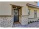 Inviting front entrance with a dark-colored door, stone accents, brick steps and a 'hello' doormat at 10360 Pescado Ln, Las Vegas, NV 89135