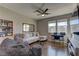 Living room with a sofa, work area, media center, television and stylish ceiling fan at 10360 Pescado Ln, Las Vegas, NV 89135