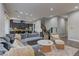 Open-concept living room showcases a large sectional sofa, modern staircase, and seamless flow to the kitchen at 10360 Pescado Ln, Las Vegas, NV 89135