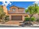 Charming two-story home features a tile roof, desert landscaping, and an attached two-car garage at 1064 Calvia St, Las Vegas, NV 89138