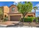 Inviting two-story home featuring a tile roof, desert landscaping, and an attached two-car garage at 1064 Calvia St, Las Vegas, NV 89138