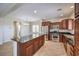 A spacious kitchen with stainless steel appliances, dark wood cabinets, and a granite countertop island at 1064 Calvia St, Las Vegas, NV 89138