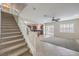 Living room with tile flooring, ceiling fan, open staircase, view to the kitchen and fireplace at 1064 Calvia St, Las Vegas, NV 89138
