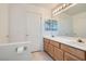 Bathroom featuring double sinks, wood cabinetry, and a mirrored medicine cabinet at 1547 Balsam Mist Ave, Las Vegas, NV 89183
