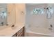 Bright bathroom showcasing a soaking tub with a tiled surround and large arched window at 1547 Balsam Mist Ave, Las Vegas, NV 89183
