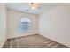 Neutral carpeted bedroom with a ceiling fan and arched window providing plenty of natural light at 1547 Balsam Mist Ave, Las Vegas, NV 89183
