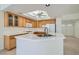 Spacious kitchen with an island, tile countertops, oak cabinets, and access to an adjacent dining area at 1547 Balsam Mist Ave, Las Vegas, NV 89183