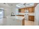 Bright kitchen with oak cabinetry, tile countertops, and modern appliances, complemented by tile flooring at 1547 Balsam Mist Ave, Las Vegas, NV 89183