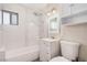 Bathroom features a shower/bath, vanity, toilet, and a tiled shower with shelving at 1832 Merze Ave, Henderson, NV 89011