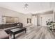 Bright living room with hardwood floors, gray sectional couch and stylish decor offers a relaxing space at 1832 Merze Ave, Henderson, NV 89011