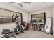 Office/bedroom with carpet flooring, two windows with blinds, and exercise equipment at 1832 Merze Ave, Henderson, NV 89011