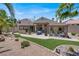 Spacious backyard with a covered patio, outdoor kitchen, manicured lawn, and desert landscaping at 2102 Rhonda Ter, Henderson, NV 89074